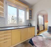 Küche in einer 3-Zimmer-Wohnung mit großem Fenster, hellen Möbeln und einem Boden mit Holzdekor.