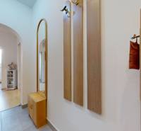 Ein Flur mit Fliesen und einer Garderobe führt in das Zimmer einer 3-Zimmer-Wohnung.