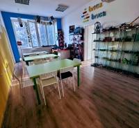 Innenraum eines Büros mit Holzboden und Tischen, Regale mit Brick-Spielzeug.