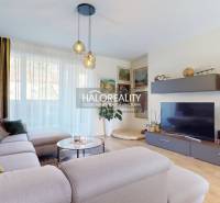 Wohnzimmer in einem Einfamilienhaus mit einem bequemen Sofa und einem Boden in Holzoptik.