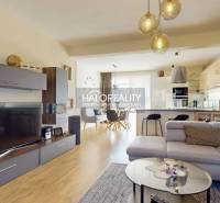 Wohnzimmer mit Holzboden, bequemer Couch und geräumiger Küche in einem Einfamilienhaus.