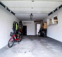 Garage in einem Einfamilienhaus mit Fahrrad und offenen Türen, geeignet zur Lagerung.