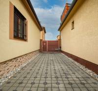 Gepflasterter Gehweg zwischen Einfamilienhäusern in der Školská-Straße in Senec.