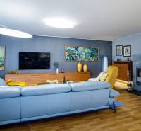 Wohnzimmer in einem Einfamilienhaus mit Kamin, Sofa und Holzboden.