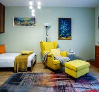 Ein Zimmer eines Einfamilienhauses mit einem Sessel, einem Bett, einem Teppich und Dekorationen. Ein Boden mit Holzdekor.