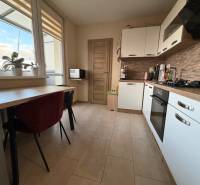 Küche in einer 4-Zimmer-Wohnung mit Fenster, Pflanzen, Küchenzeile und eingebauten Geräten.