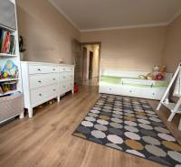 Kinderzimmer mit Bett, Teppich und Boden mit Holzdekor in einer 4-Zimmer-Wohnung.