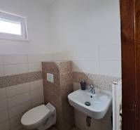 Toilette in einer 4-Zimmer-Wohnung mit weißen und gemusterten Fliesen.