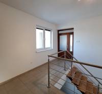 Flur mit Keramikfliesen und Treppe in einer 4-Zimmer-Wohnung.