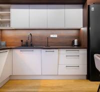 Küche in einer Einzimmerwohnung mit Holzboden und modernen Geräten.