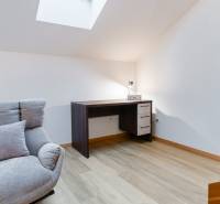 Sessel, Schreibtisch und Boden mit Holzdekor in einer Einzimmerwohnung.