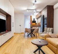 Wohnzimmer mit Holzboden, bequemer Couch und Küchentisch.