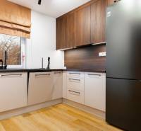 Küche in einer Einzimmerwohnung mit Holzboden und modernen Geräten.