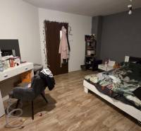 Schlafzimmer mit Bett, Schreibtisch und Holzboden in einem Einfamilienhaus.