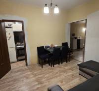 Wohnzimmer in einem Einfamilienhaus mit Holzboden, Tisch und Sofa.