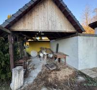Unterstand bei einem Einfamilienhaus in Demandice, altes Holz und Werkzeuge im Hof.