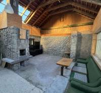 Innenraum eines Einfamilienhauses mit Steinkamin und Holzverkleidung.