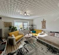 Wohnzimmer in einer 2-Zimmer-Wohnung mit Holzboden und bequemen Sitzgelegenheiten.