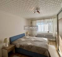 Helles Schlafzimmer mit Deckenlicht und Holzboden in einer Zweizimmerwohnung.