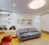 Wohnzimmer mit Sofa, Esstisch und Holzboden in einer 3-Zimmer-Wohnung.