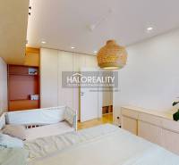 Kinderzimmer mit Bett, Rattanlampe und Kleiderschrank in einer 3-Zimmer-Wohnung.