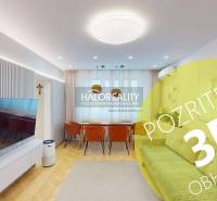 Wohnzimmer in einer 3-Zimmer-Wohnung mit Fernseher, Sofa und Holzboden-Dekor.