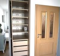 Einbauschrank mit Regalen und Schubladen, in einer 2-Zimmer-Wohnung platziert.