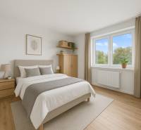 Helles Schlafzimmer in einer 2-Zimmer-Wohnung mit Holzboden und großem Fenster.