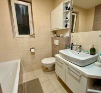 Badezimmer mit Badewanne und weißem Waschbecken in einer 2-Zimmer-Wohnung.