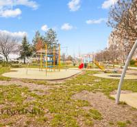 Ein Kinderspielplatz, umgeben von Plattenbauten in Senec, ideal für Familien mit Kindern.