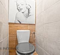 Toilette in einer 3-Zimmer-Wohnung mit Holzboden und einem Wandfoto.