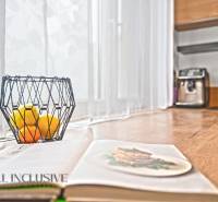 Offene Küche in einer 3-Zimmer-Wohnung mit Holzdekor, Obstschale auf dem Tisch.