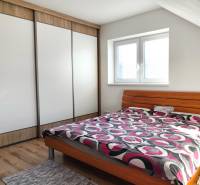 Das Schlafzimmer im Einfamilienhaus enthält ein Bett, einen Schrank und einen Boden mit Holzdekor.