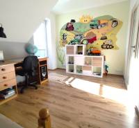 Kinderzimmer in einem Einfamilienhaus mit Holzboden und fröhlichem Wandgemälde.