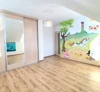 Kinderzimmer mit Holzboden, Schiebetürenschrank, bemalte Wand mit Naturmotiv.