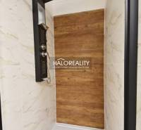 Duschkabine mit Holzboden und Marmorkacheln in einem Einfamilienhaus.