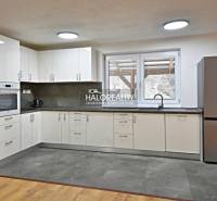 Eine Küche in einem Einfamilienhaus mit modernen Geräten und einem Boden in Holzoptik.