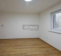 Ein leerer Raum mit Holzboden, einem Fenster und hellen Wänden in einem Einfamilienhaus.