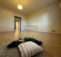 Ein Zimmer mit Holzboden in einer 3-Zimmer-Wohnung, Beleuchtung, Wände in heller Farbe.