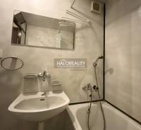 Badezimmer in einer 3-Zimmer-Wohnung mit Badewanne, Spiegel und weißem Waschbecken.