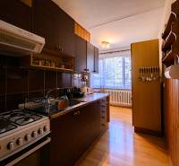 Küche in einer 2-Zimmer-Wohnung mit Arbeitsplatte und Boden in Holzoptik.