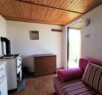 In der gemütlichen Hütte gibt es einen Vintage-Herd, eine Holzdecke und ein bequemes Polstersofa.