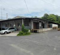 An der Straße Železničná steht bei den Lagern und Hallen ein Gebäude mit Autos und Holz.