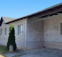 Industriegebäude in der Straße Železničná, umgeben von Grünflächen, Hallen und Lager im Hintergrund.