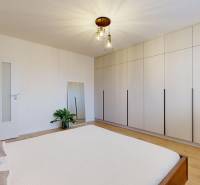 Schlafzimmer in einer 3-Zimmer-Wohnung mit einem großen Schrank und einem Boden in Holzoptik.
