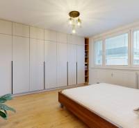 Schlafzimmer in einer 3-Zimmer-Wohnung mit einem großen Schrank und einem Boden in Holzoptik.