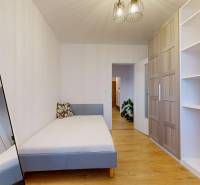 Schlafzimmer in einer 3-Zimmer-Wohnung mit Holzboden, Schrank und Spiegel.