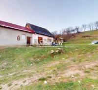 Ein Einfamilienhaus in Klenovec am Hang, mit einer daneben stehenden Bank und grüner Umgebung.