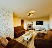 Wohnzimmer einer 3-Zimmer-Wohnung mit Holzboden und bequemen Sitzmöbeln.