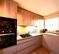 Küche mit Holzdekor, Einbaugeräte in einer 3-Zimmer-Wohnung.